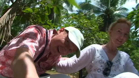 Guy funny dodging tree branches while traveling on the roof of car on safari Stock Footage 52930812