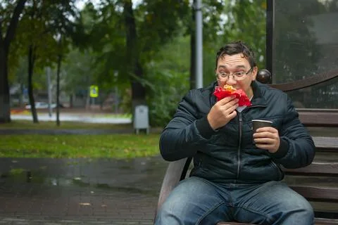 Guy with a funny facial expression bites, eats a sweet donut Stock Photos