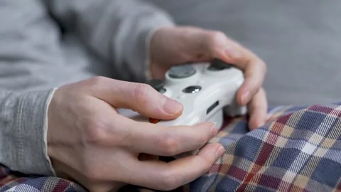 The Guy Gamer Plays Computer Games Using a Gamepad, Close-up. The Fingers Press  Stock Footage 141579437