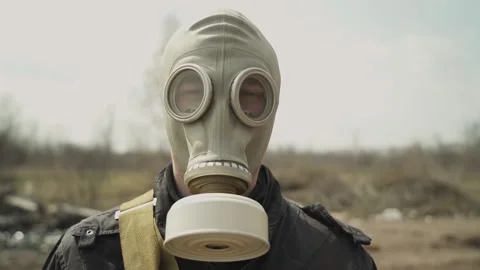 A guy in a gas mask nods to the camera. average plan. on the background dump Stock Footage 130427720