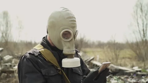 Guy in the gasmask. amid the landfill. dials the phone and calls. does his head Stock Footage 130427751