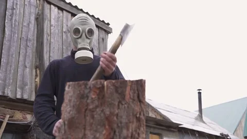 Guy in the gasmask with an ax colitis firewood. slow motion. blurred background Stock Footage 130523448