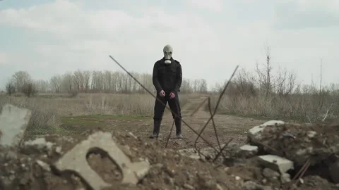 Guy in the gasmask terms against the background of the landfill dances Stock Footage 130428070