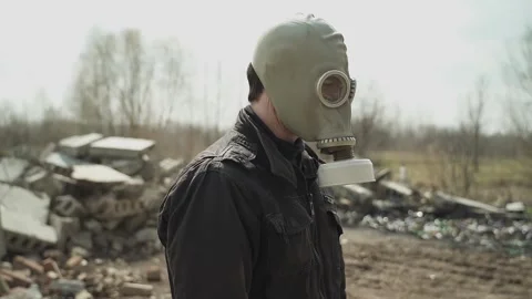 Guy in the gasmask, turns to the camera and crossing his arms on his chest nods Stock Footage 130427635