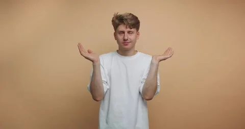 Guy gestures playfully while expressing various emotions in a studio with a.. Stock Footage 317328065