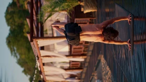 The guy gets to his feet during a yoga class on the beach. Harmony of body and Vídeos de archivo 249235134