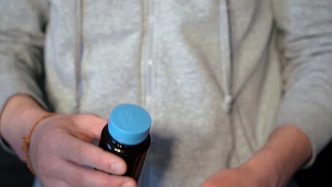 The guy gets out of the banks of the capsule, medicine, medication. closeup. Видео 128451071