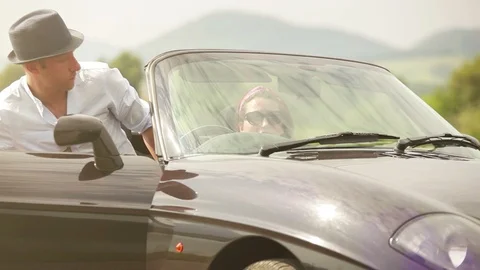 Guy getting into convertible car while his girlfriend waiting for him there Stock-Footage 116426436