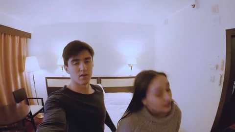 The guy with the girl is looking at the camera and falling on the bed Stock Footage 74025883