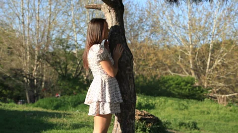 The guy with the girl play hide-and-seek around the tree Stock Footage 33953681