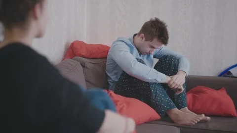 Guy with a girl is sitting on the couch and thinking Video stock 80532591