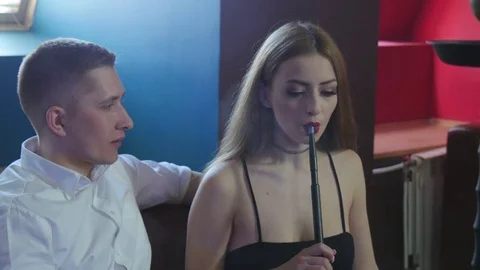 The Guy with The Girl is Sitting on The Sofa in The Cafe and Smoking a Hookah Stock Footage 75260188
