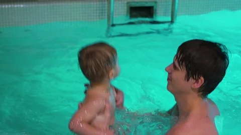 The guy giving the baby a bath in the pool 動画素材 71639213