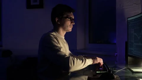 Guy with glasses is sitting in a dark office in front of a monitor Stock Footage 219202654