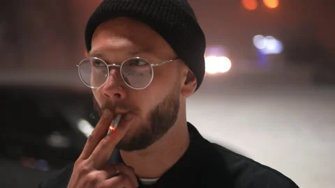 The guy with glasses smokes a cigarette. Winter Stockbeeldmateriaal 147978886