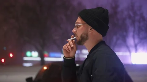 The guy with glasses smokes a cigarette. Winter. Stockbeeldmateriaal 147978901