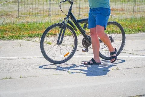 Guy goes with the bike on the road Stock-Fotos