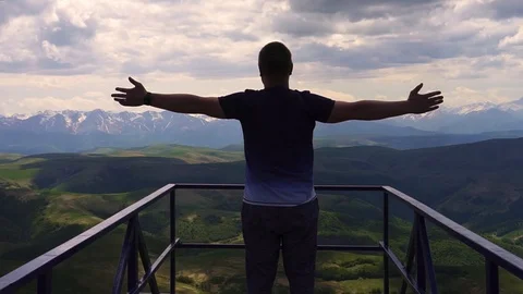 The guy goes to the bridge overlooking the mountains and the forest Vídeo Stock 109214674