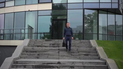 The guy goes down the stairs after working day. Video stock 113555820