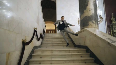 The guy goes down the stairs and bounces his shoes against each other. Cool mood Stock Footage 166059164
