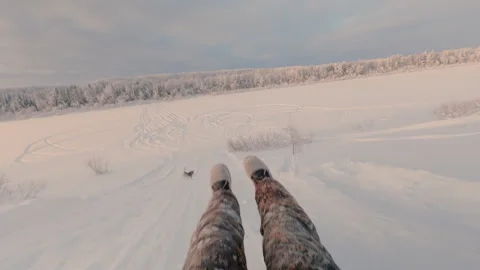 A guy goes downhill on a sled in winter at high speed. A snow tubing run. Stock Footage 325860149