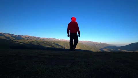 The guy goes to the edge of hill and admires view Vídeos de archivo 205319933
