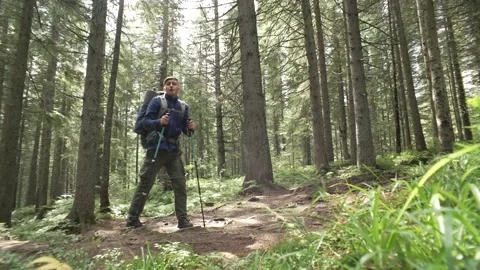 A guy goes hiking in the mountains with a backpack on his shoulders. Stock Footage 213018168
