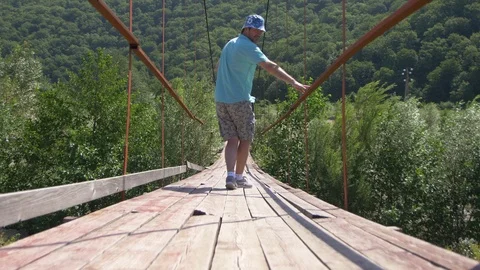 Guy Goes on the Old Tension Bridge Stock Footage 105263092