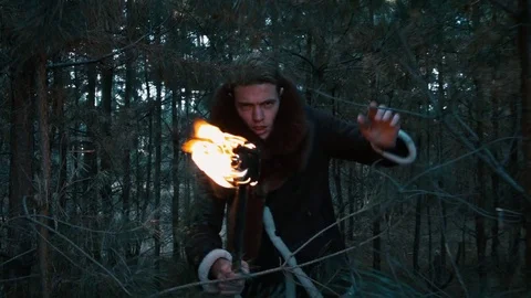 The guy goes through the forest with a torch Stock Footage 70765066