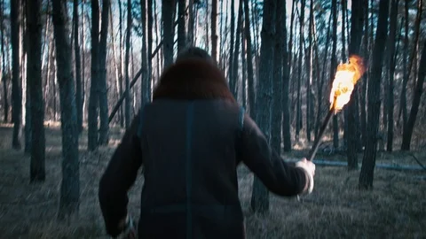 The guy goes through the forest with a torch Video stock 70765445