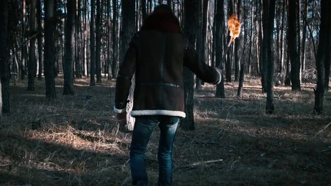 The guy goes through the forest with a torch Video stock 70765545