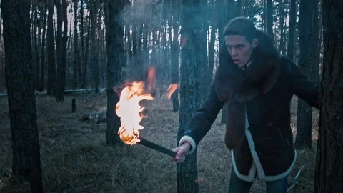 The guy goes through the forest with a torch Stock Footage 70765564