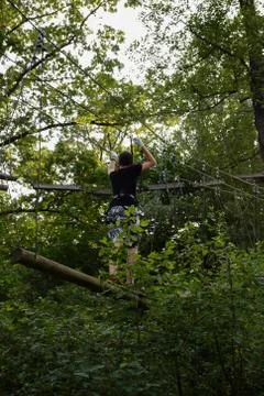 The guy goes through the obstacle course on the rope park Stock Photos