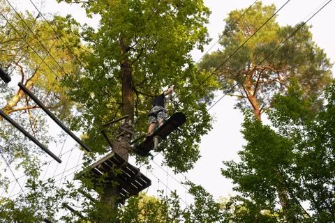 The guy goes through the obstacle course on the rope park Stock Photos