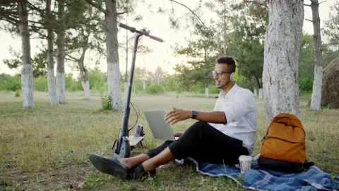 A guy good looking after the work came in the park with electric scooter take a Stock Footage 138167361