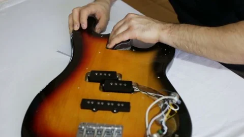 Guy grinds the deck of the guitar. Medium shot, Day, indoors, real time Stock Footage 83561874