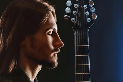The guy with the guitar in the dark 库存照片