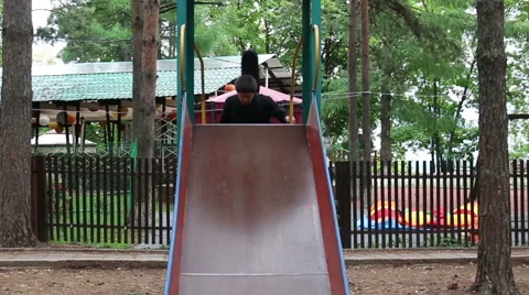 The guy with a guitar on a Hill, Playground, Counts and Slides Down, a Small Stock Footage 64862456