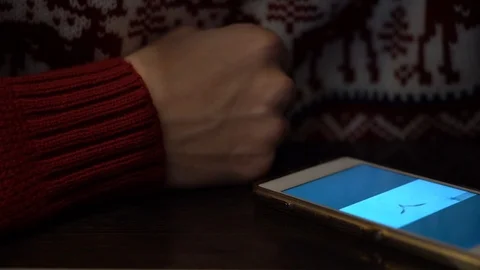 Guy hand with phone on the table. Man can not find button and turn down sound. Stock Footage 108005111