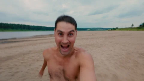 The guy is happily running along the beach, enjoying his freedom. Stock Footage 314518853