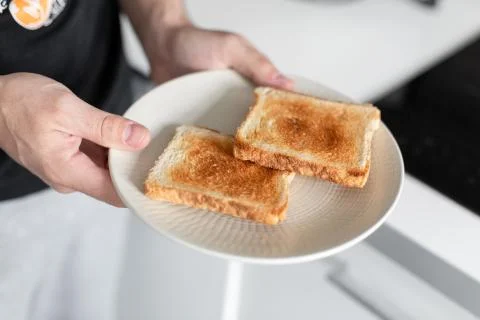 The guy has breakfast with toast with jam. Foto stock