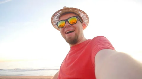 Guy in hat gets a selfie during his vacation at sea Stock Footage 89062677