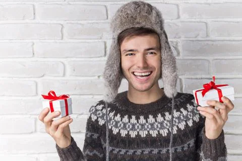 Guy in the Hat Holding Presents and Laughing. Winter concept Stock Photos