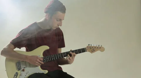 Guy in hat playing guitar in the studio in the smoke Stock Footage 48056510