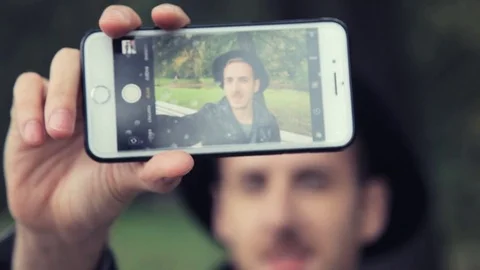 A guy in a hat taking pictures of themselves Stock-Footage 80492990