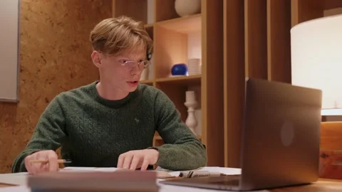 Guy having conference video call on laptop at home, explaining something Stock Footage 164380385