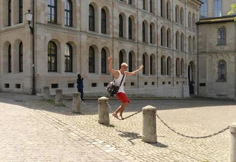 A guy having fun balances on the chain in center of Zurich. Stock Photos