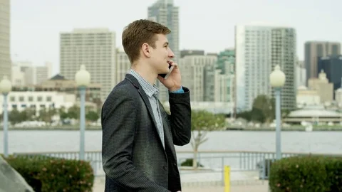 Guy is having a joyful talk over the cellphone on a street Stock Footage 75675486