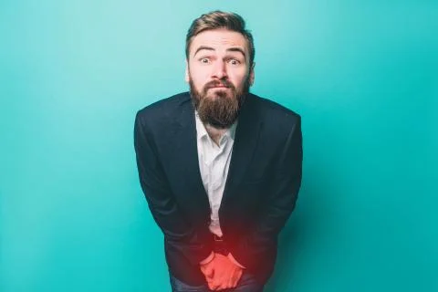 Guy is having problem with peeing. It is very painful for him. Isolated on blue Stock Photos