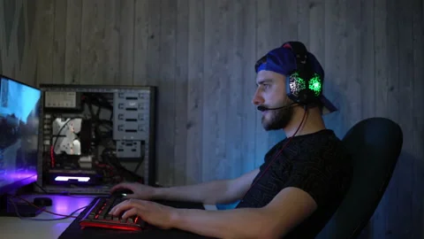 The guy in the headphones plays computer games and talks into the microphone Stock Footage 149216380